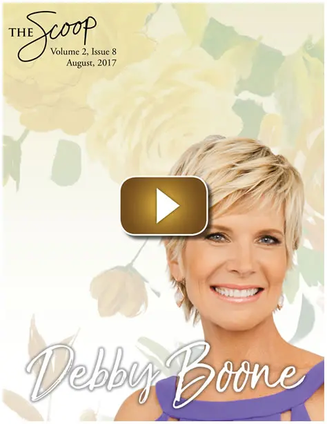 Smiling woman with short blonde hair against a floral background.