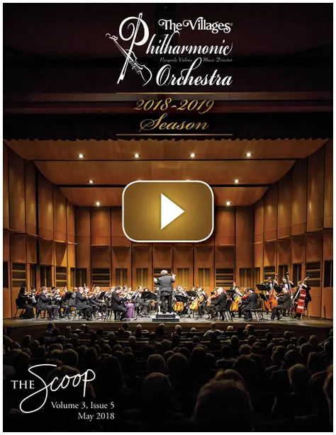 Symphony orchestra performing on stage in a concert hall.