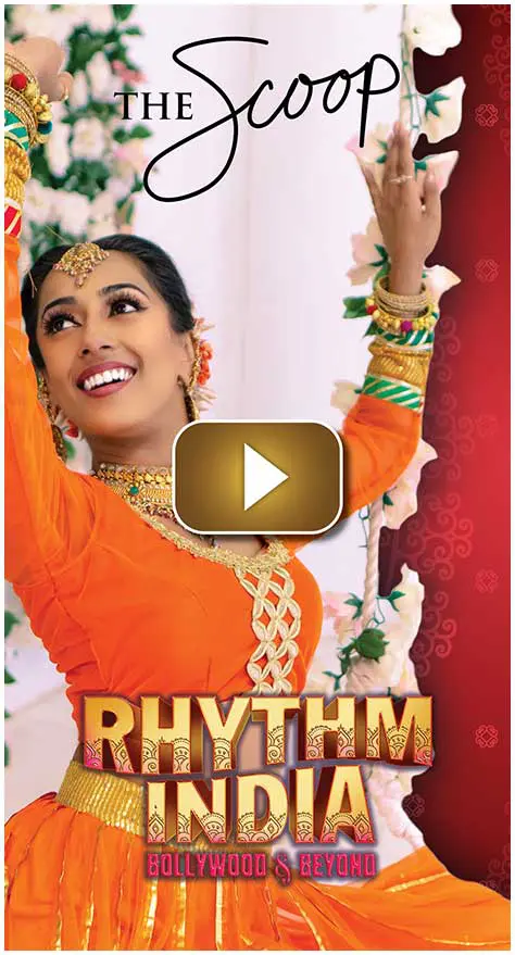 A joyful woman in traditional attire dancing with vibrant jewelry.