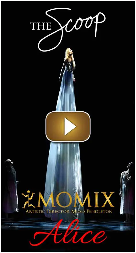 Tall statue illuminated at night with two people nearby.