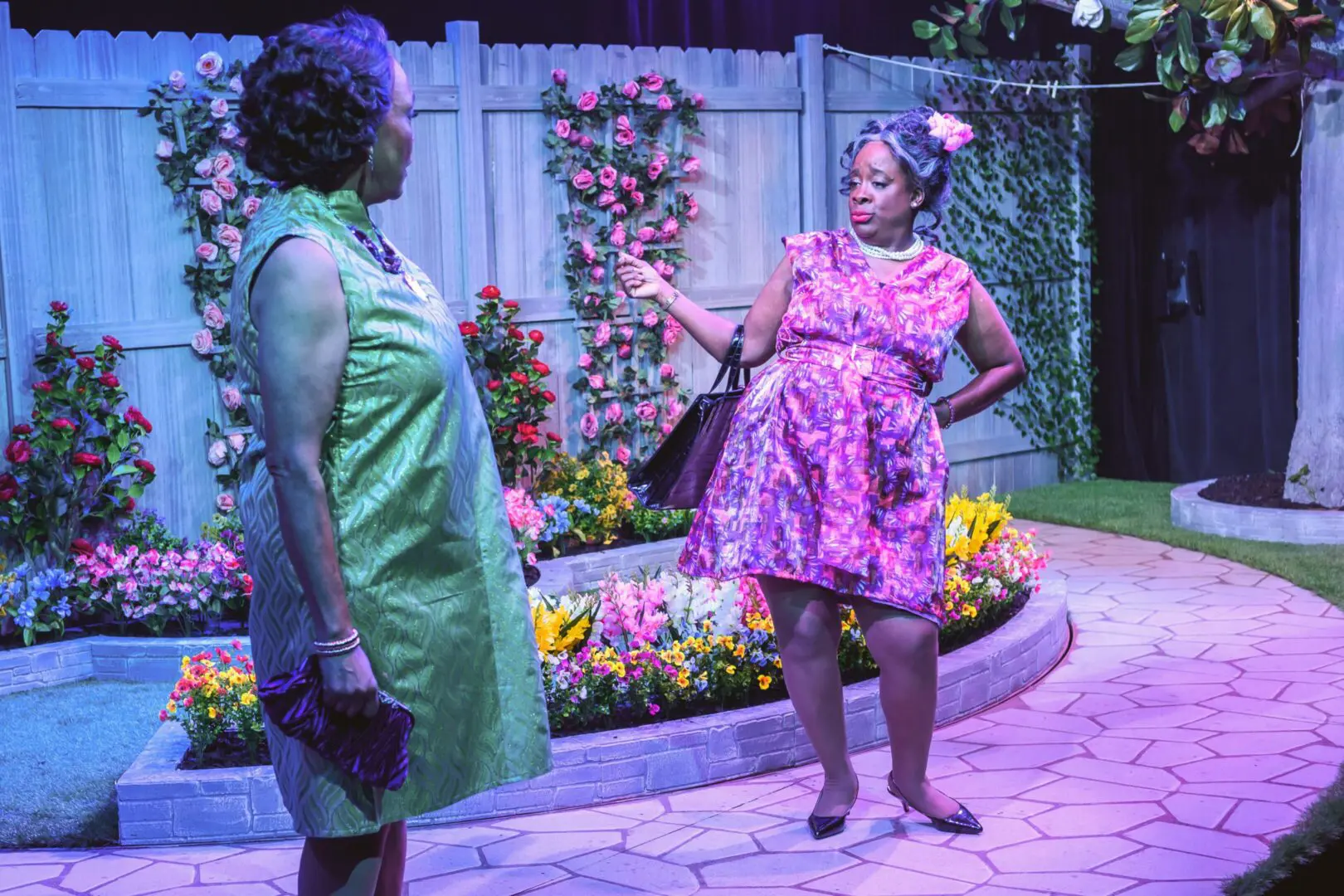 Two women conversing in colorful garden setting