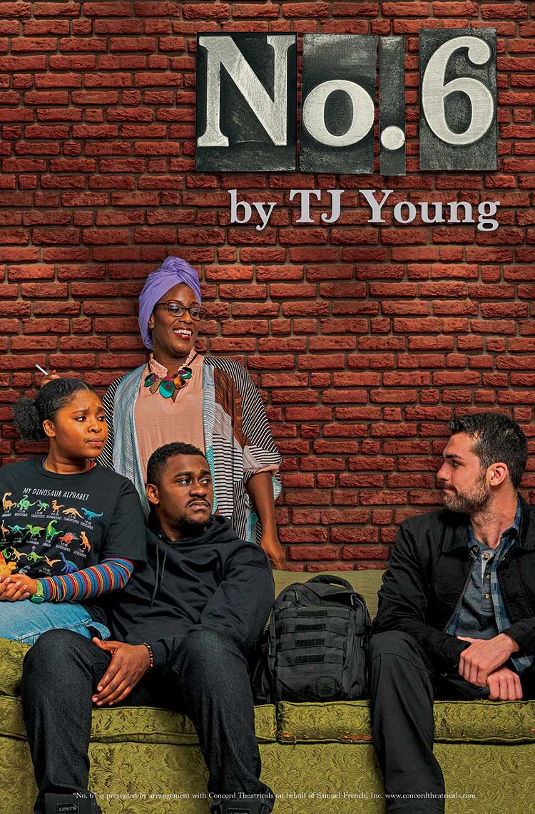 Four people sitting and standing against a brick wall, engaging in conversation.